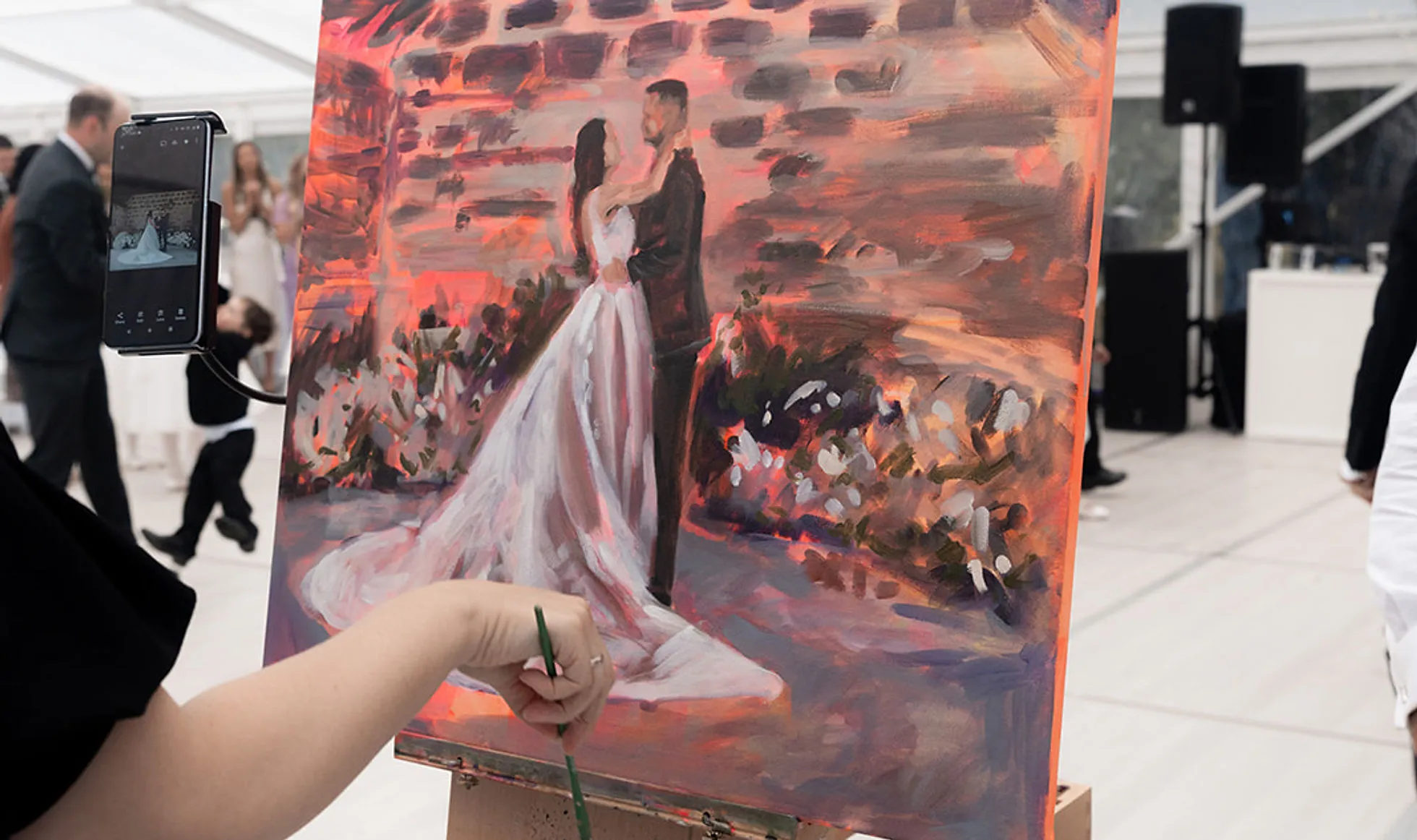 Olga painting a wedding couple live at the reception